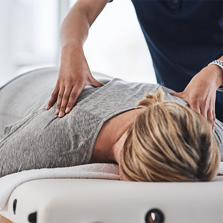 Woman Lying Down Receiving A Non-Surgical Spine Care Adjustment