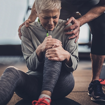Woman Sitting On the Ground With A Knee Injury